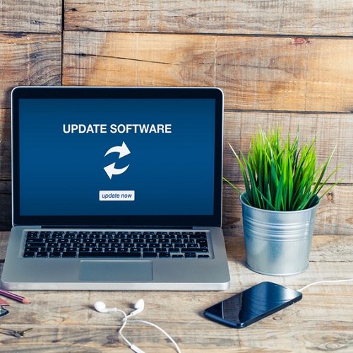 Update software notice in a laptop. Wooden desk office.